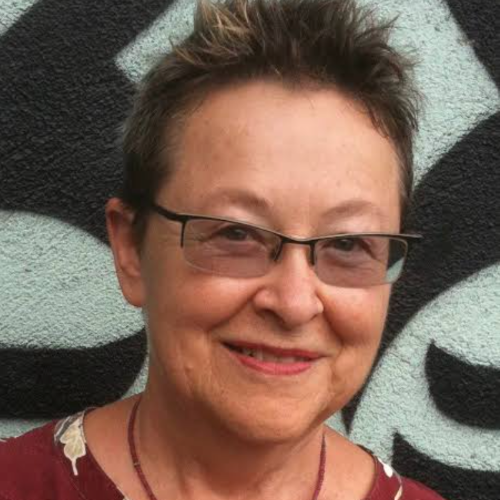 Close-up photo of Adrienne Mayor, wearing glasses and a gentle smile.